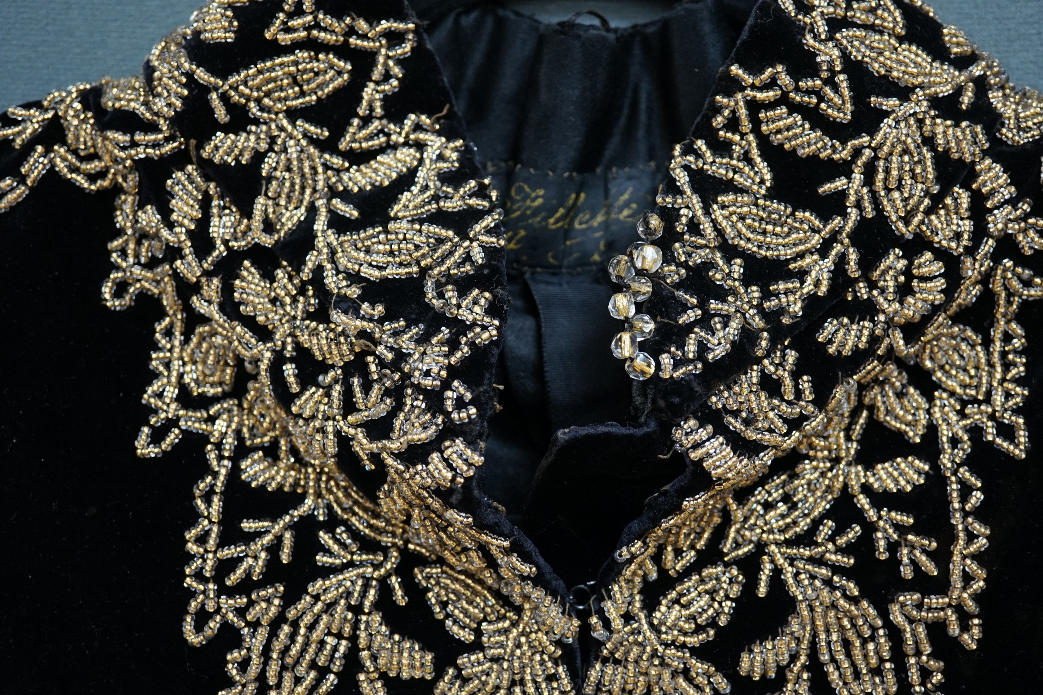 An Edwardian French black velvet and elaborately beaded evening over collar, with makers label, ‘Fillet’, designed with a high collar, front and back panels, all heavily bead worked in an intricate floral design, attache